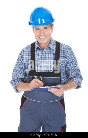 Technician Writing On Clipboard Over White Background Stock Photo