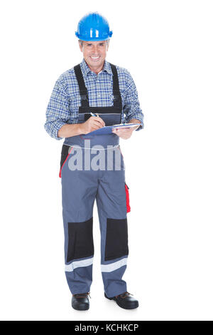 Technician Writing On Clipboard Over White Background Stock Photo