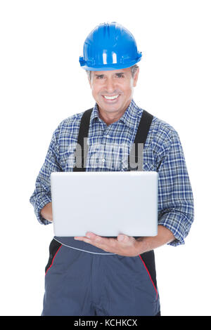 Worker wearing hard hat and using laptop. Isolated on white Stock Photo