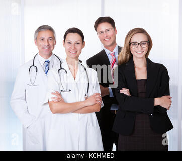 Portrait Of Confident Businesspeople And Medical Workers Standing Together Stock Photo
