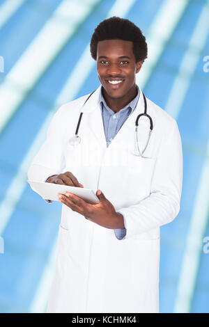 Portrait Of Male African Doctor Using Digital Tablet Stock Photo