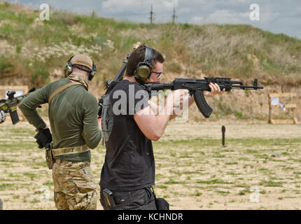 Men shooting outdoors Stock Photo - Alamy