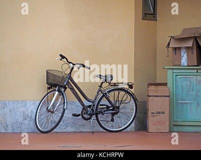 shopper's bike parked alongside cardboard boxes in Tuscany, Italy Stock Photo