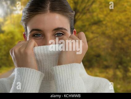 Digital composite of Woman in Autumn with jumper tight in forest Stock Photo