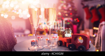 Champagne flutes with Christmas decorations on table at home Stock Photo