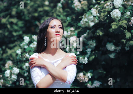 Beautiful bride stands near the lake and waits for the groom Stock Photo