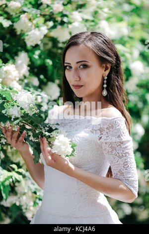 Beautiful bride stands near the lake and waits for the groom Stock Photo