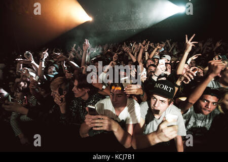 The atmosphere is ecstatic at VEGA in Copenhagen when the American hip-hop collective ASAP Mob performs a live concert. Here energetic rap and music fans a filming and taking pictures with their smart phones during the show. Denmark, 03/11 2014. Stock Photo