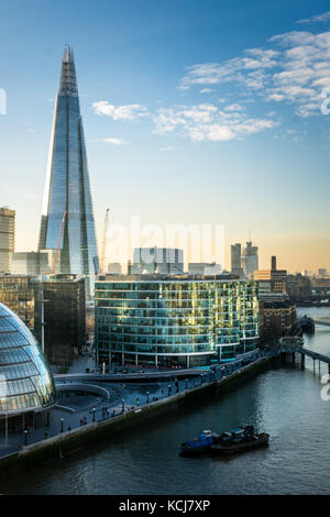 The Shard and City Hall on the south bank of The Thames in London at sunset Stock Photo