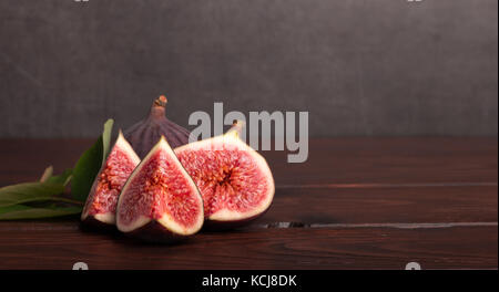 ripe fresh sliced figs on wooden table Stock Photo