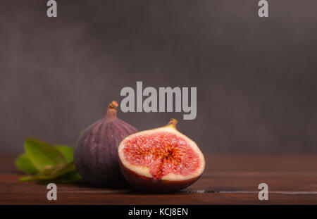 ripe fresh sliced figs on wooden table Stock Photo