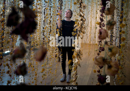 Artist Rebecca Louise Law puts the finishing touches to her new hanging installation 'Life in Death' featuring 375,000 flowers, at the Shirley Sherwood Gallery of Botanical Art, part of Artful Autumn at Kew Gardens in south west London. Stock Photo