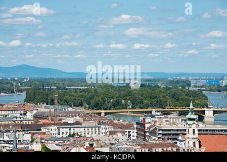 An aerial cityscape view over Budapest showing Margaret Island on a sunny day with blue sky. Stock Photo
