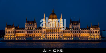 A 2 picture stitch evening nighttime view of the Hungarian Parliament Building on the Danube river in Budapest. Stock Photo