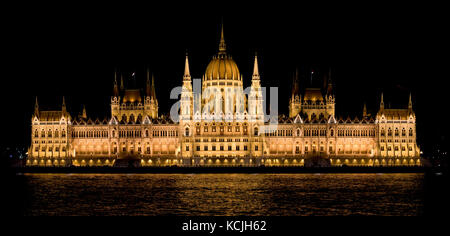A 2 picture stitch evening nighttime view of the Hungarian Parliament Building on the Danube river in Budapest. Stock Photo