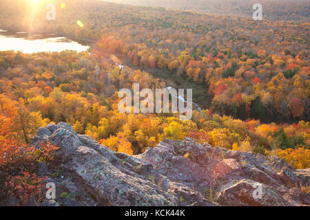 Autumn trees in full color with rocky cliff edge at Lake of the Clouds Michigan. Taken at sunrise. Stock Photo