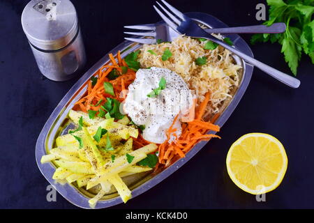 Fresh salad with celery, apple, carrot with yogurt on a metal plate on a grey background. Healthy eating concept. Dieting Stock Photo