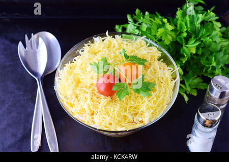 Salad with chicken liver in layers with pickles,boiled carrot, egg, cheese in a glass bowl on a black abstract background. Top view. Healthy food conc Stock Photo