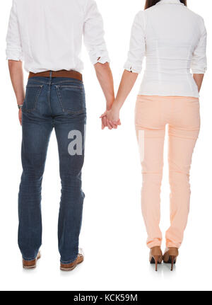 Young Couple Holding Hands Over White Background Stock Photo