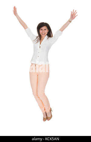 Happy Woman With Arm Raised Over White Background Stock Photo