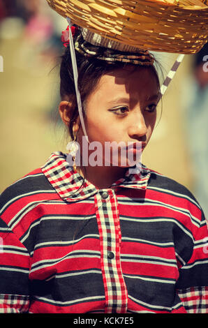 Portrait of Filipino girl wearing ethnic minority costume and carrying traditional basket on head at the Baguio flower festival in the Philippines Stock Photo