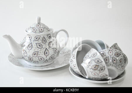 decorated with oriental teapot and bowls on a plate on a white background Stock Photo