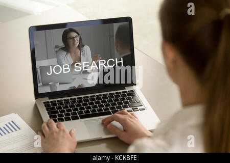 Woman looking for job on laptop at work desk. Office worker using search engine, searches for different job. Employee contemplates new career opportun Stock Photo