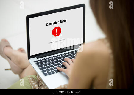 Woman in nice dress looking at Operation Error on laptop screen. Software failure, app stopped working, computer unit broke, system crashed unexpected Stock Photo