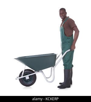 Happy Male Gardener Holding Wheelbarrow Over White Background Stock Photo