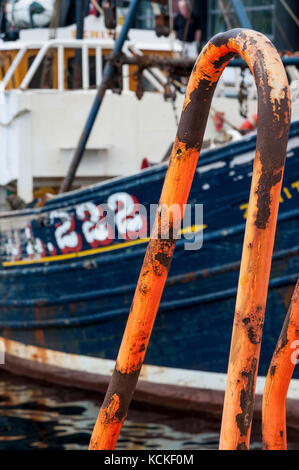 Ullapool, Scotland - August 15, 2010: Detail of a rusty handrail with a fishing boat on the background in the village of Ullapool in the Highlands in  Stock Photo