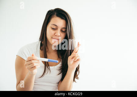 Young woman looking at pregnance test in happiness Stock Photo