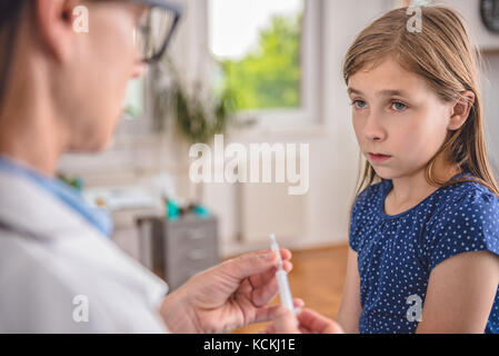Pediatrics female doctor preparing a vaccine to inject into a patient Stock Photo