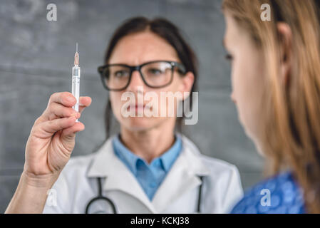Pediatrics female doctor preparing a vaccine to inject into a patient Stock Photo