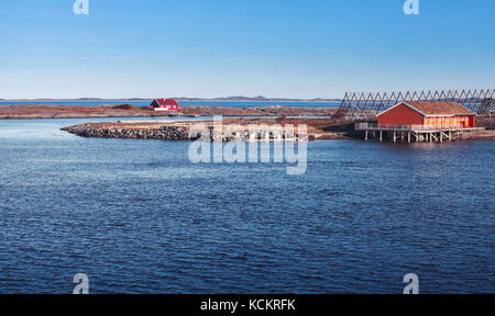 Coastal rural Norwegian landscape, traditional red wooden houses on rocky islands Stock Photo