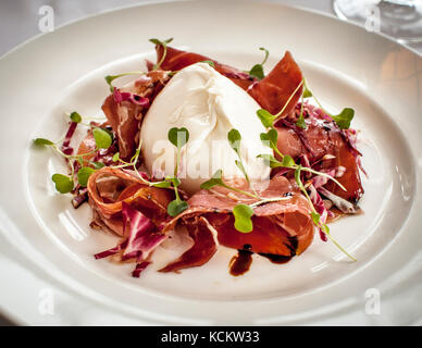 Parma ham with burratta and radicchio. Dinner dish in Tresanton Restaurant Stock Photo