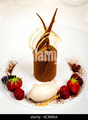 The wonderful desserts like this shock cake with Timut pepper on Tonka ice cream are decorated by Florent Jestin. Chocolate Desert by Michelin Star Chef Loïc Le Bail Stock Photo