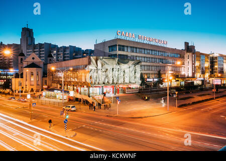 Minsk, Belarus - April 3, 2017: Evening Night Traffic Near Cathedral of Saints Peter and Paul and Bas-relief of the Soviet era on old facade building  Stock Photo