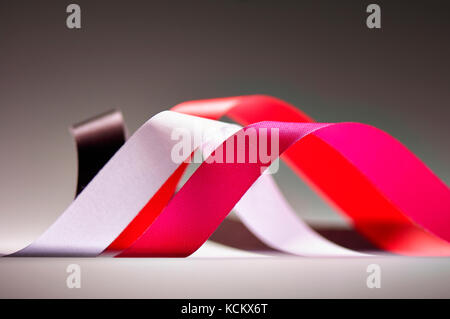Four curled ribbons in pink, red, brown and white color Stock Photo