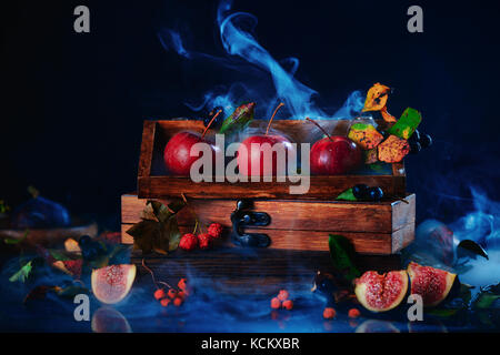 Three tiny apples in a wooden crate. Website header. Dark food photography with copy space. Stock Photo