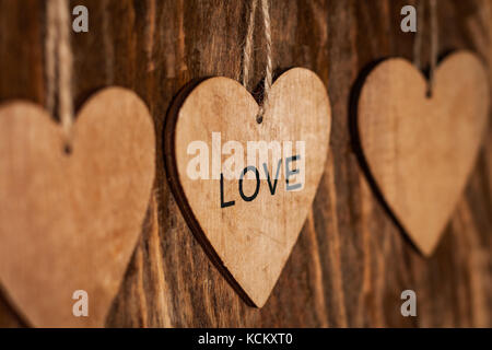 Wooden Brown Heart With Inscription: 'LOVE' On Wooden Background Close Up. Stock Photo