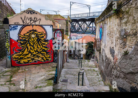 Graffiti on the wall in Ribeira district in Porto city on Iberian Peninsula, second largest city in Portugal. View with Dom Luis I Bridge Stock Photo