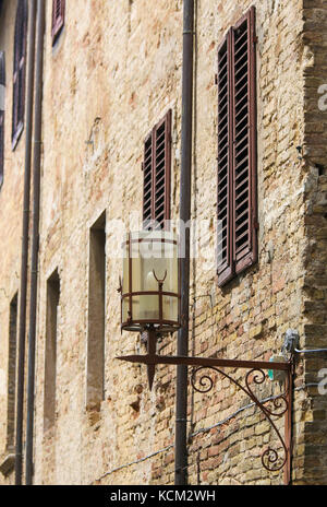 Lantern and wall of a historic house in the center of San Gimignano, Tuscany, Italy Stock Photo