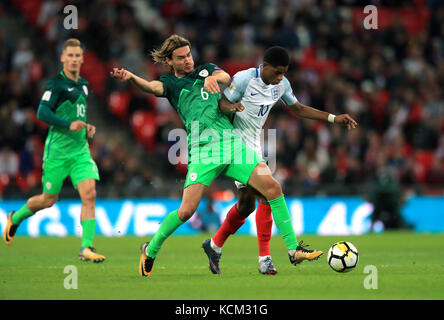 Slovenia's Rene Krhin (left) and England's Marcus Rashford (right) battle for the ball during the 2018 FIFA World Cup Qualifying, Group F match at Wembley Stadium, London. Stock Photo