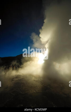 Chile Atacama Desert. Geyser del Tatio( 4.300 m.). decine di piccoli geyser, solfatare, pitte di fango e soffioni costellano questo altipiano.All'alba le colonne di vapore sono molto alte| Chile Atacama Desert tens of small geysers, fumaroles, mud pitts are all around this magnificient high plateau. At sun rise, the vapor collums are a lot higher. Waiting the sun rise while the moon sets. Stock Photo