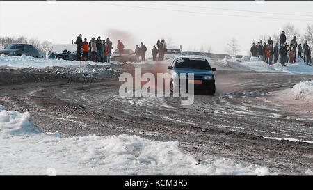 Rally car goes on dirt. ars go off-roading in race. Rally car going down slope in race at Sun City. Dirty rural road with puddles and mud under dark dramatic stormy sky, SUV car goes far away. Stock Photo