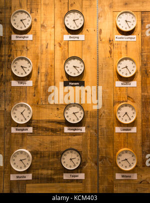 Clocks with time zone of different country on wooden shelves background ...