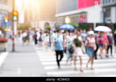 Blur crowd of people crossing down the street rush on the street in city life with flare light effect. The image is purposely made out of focus, no fa Stock Photo