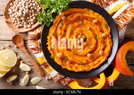 Delicious pumpkin hummus with ingredients on the table close up. Horizontal top view from above Stock Photo