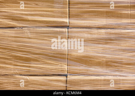 Shrink wrapping on a stacked cardboard boxes. Delivery background Stock Photo