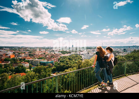 Vilnius, Lithuania - July 5, 2016: Two Young Girls Women Looking At View Of Vilnius Old Town From Viewing Platform Near Three Crosses Monument. Unesco Stock Photo